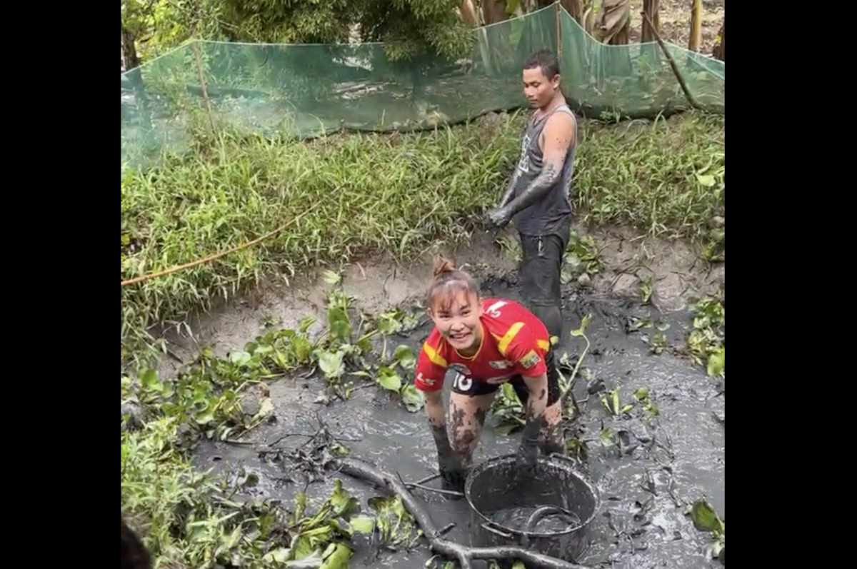 Bất ngờ hình ảnh trụ cột đội tuyển nữ Việt Nam mang quần đùi áo số, lội bùn bắt cá cùng gia đình